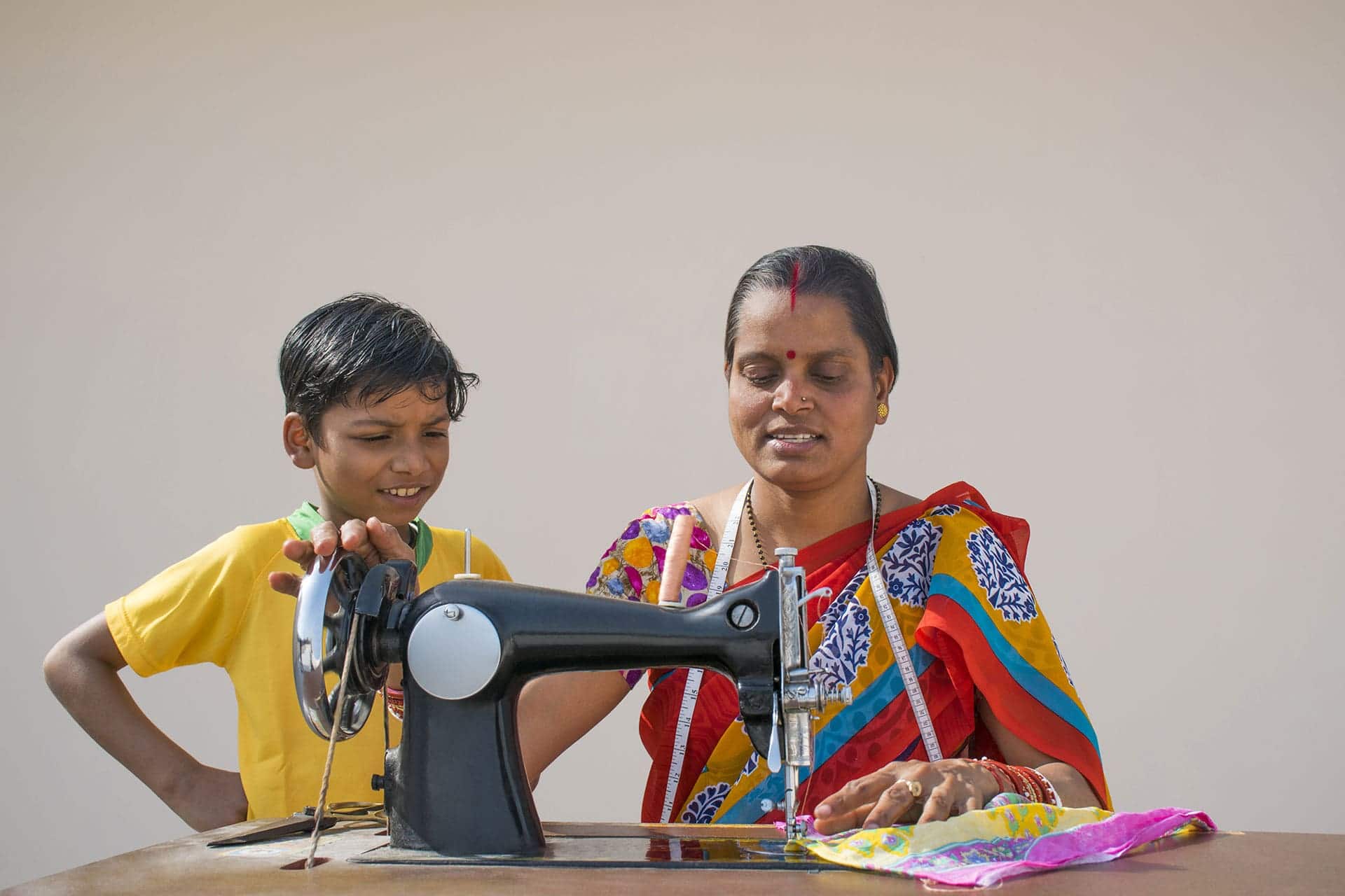 indian woman and boy sewing